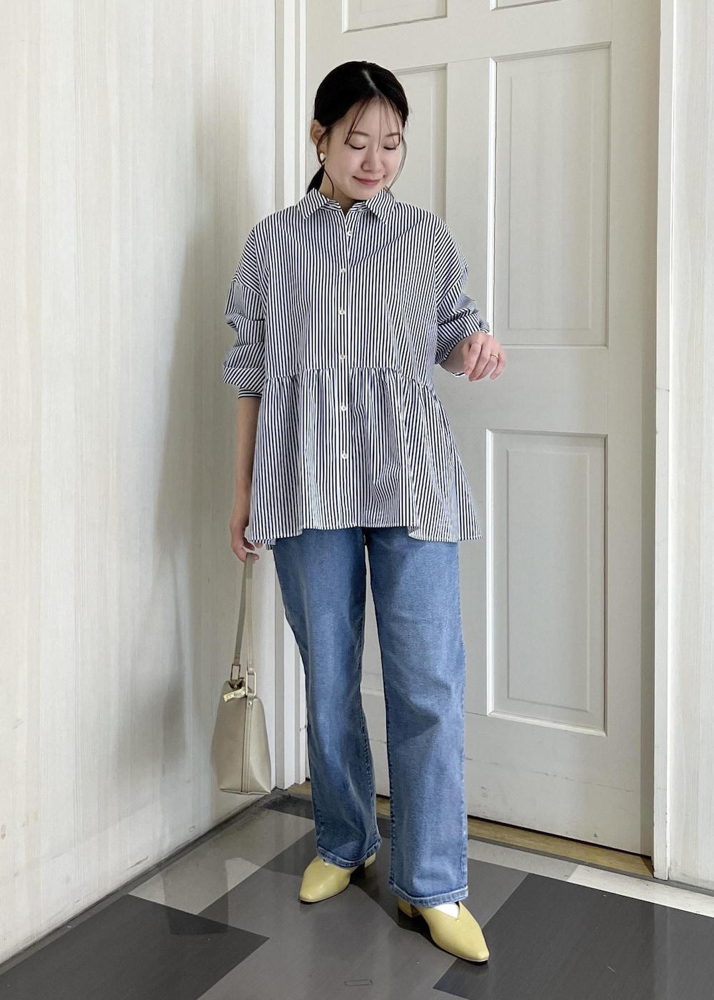 ブラウン系のボストンバッグ、ブルー系のトレンチコート、ブルー系のシャツ/ブラウスを着用したレディースの春コーディネートの6枚目の写真