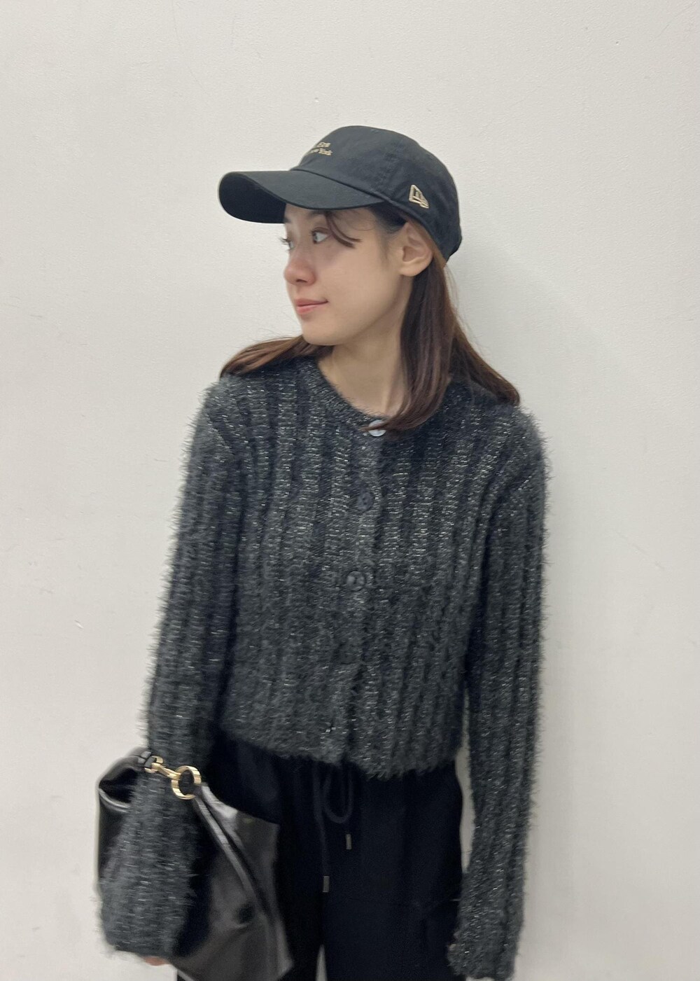 ブラック系のカーゴパンツ、グレー系のカーディガン/ボレロ、ブラック系のショルダーバッグを着用したレディースの冬コーディネートの4枚目の写真