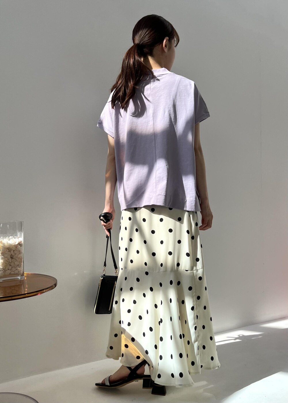 ブラック系のショルダーバッグ、パープル系のTシャツ/カットソー、ブラック系のサンダルを着用したレディースの春コーディネートの2枚目の写真