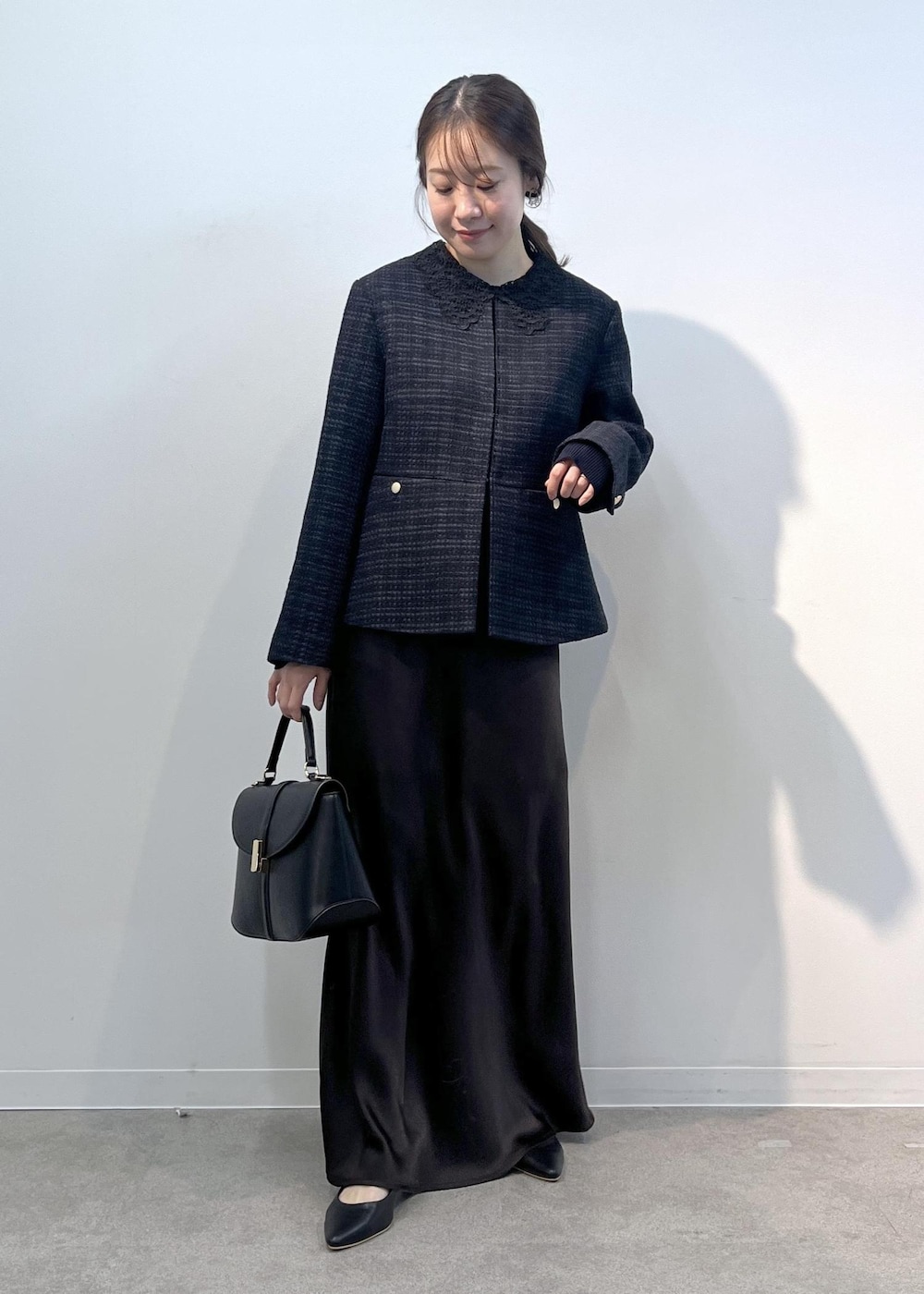 ブルー系のノーカラージャケット、ブラック系のショルダーバッグ、ブルー系のニット/セーターを着用したレディースの冬コーディネートの2枚目の写真
