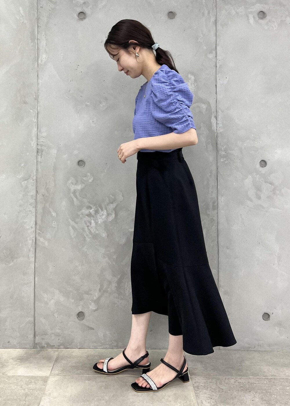 ブルー系のTシャツ/カットソー、ブラック系のサンダル、ブラック系のスカートを着用したレディースの夏コーディネートの2枚目の写真