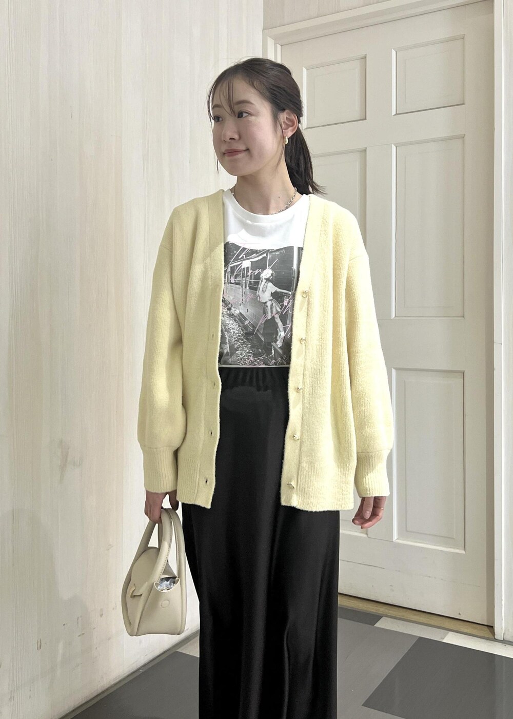 ホワイト系のショルダーバッグ、シルバー系のスニーカー、ベージュ系のカーディガン/ボレロを着用したレディースの冬コーディネートの5枚目の写真