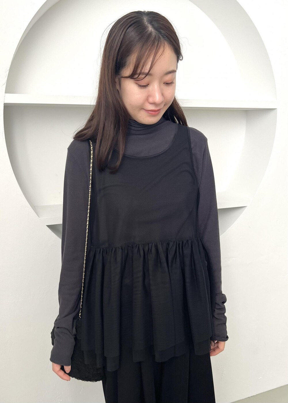 グレー系のTシャツ/カットソー、ブラック系のその他パンツ、ブラック系のショルダーバッグを着用したレディースの冬コーディネートの3枚目の写真