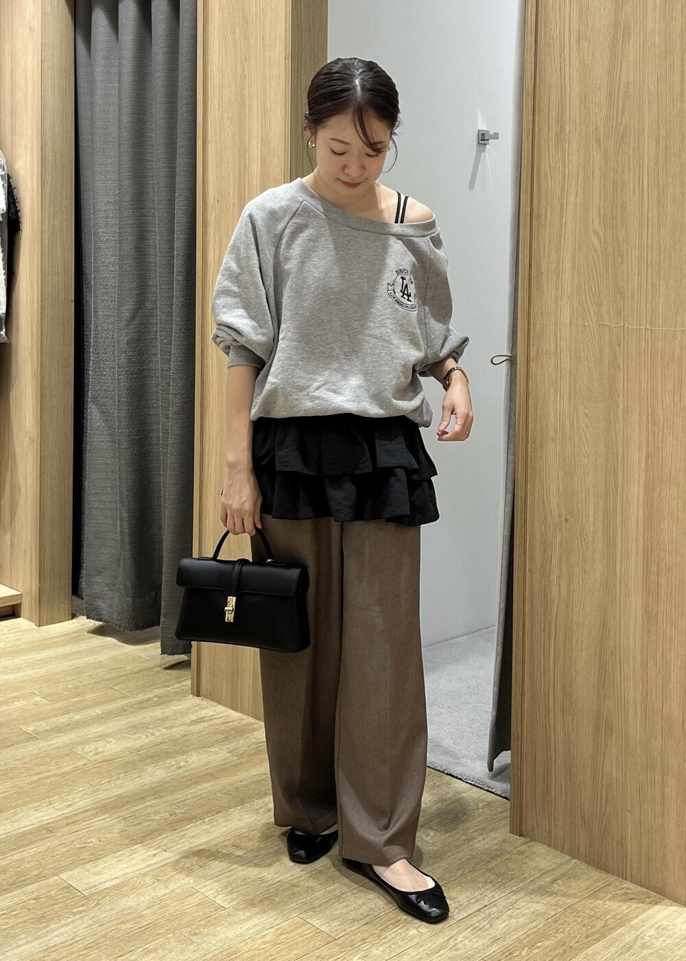 ブラック系のショルダーバッグ、ブラック系のキャミソール、グレー系のスウェットを着用したレディースの秋コーディネートの2枚目の写真