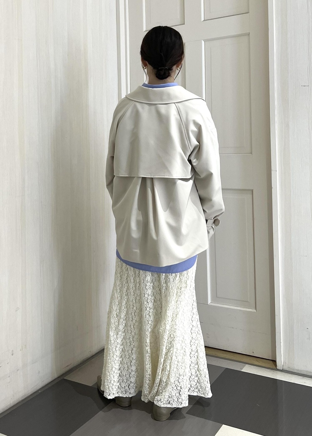 ブラウン系のボストンバッグ、ベージュ系のパンプス、ホワイト系のスウェットを着用したレディースの冬コーディネートの5枚目の写真