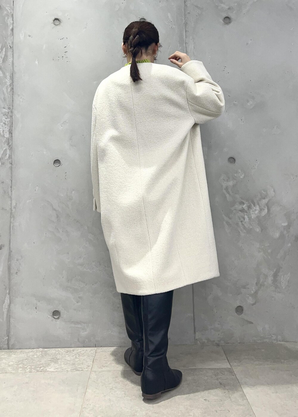 グリーン系のニット/セーター、ベージュ系のスカート、ホワイト系のその他アウターを着用したレディースの冬コーディネートの3枚目の写真