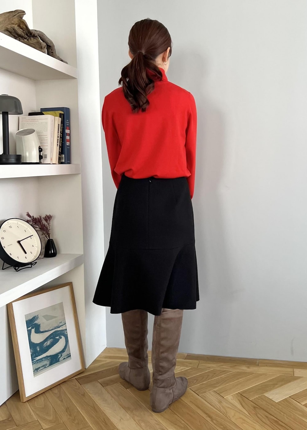 ブラック系のスカート、レッド系のニット/セーター、ベージュ系のブーツを着用したレディースの冬コーディネートの3枚目の写真