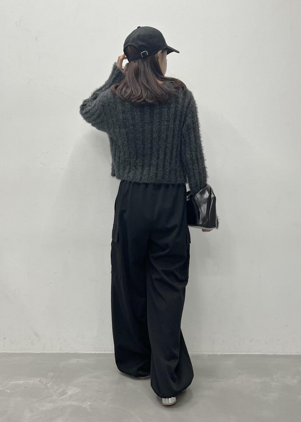 ブラック系のカーゴパンツ、グレー系のカーディガン/ボレロ、ブラック系のショルダーバッグを着用したレディースの冬コーディネートの3枚目の写真