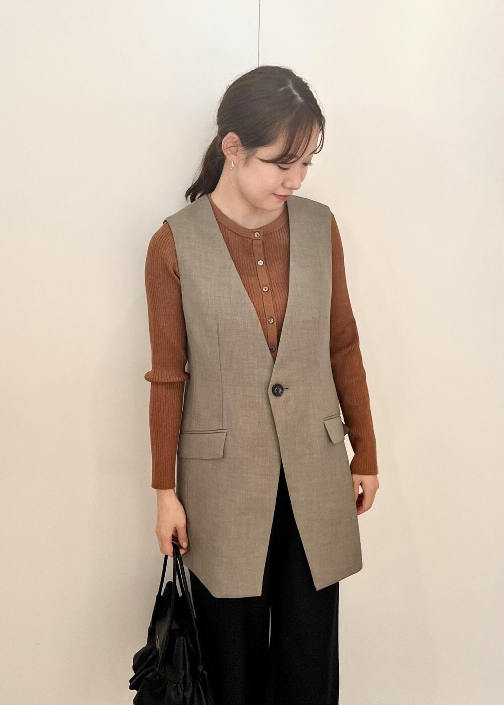 ブラック系のトートバッグ、ブラック系のその他パンツ、ブラウン系のカーディガン/ボレロを着用したレディースの秋コーディネートの4枚目の写真