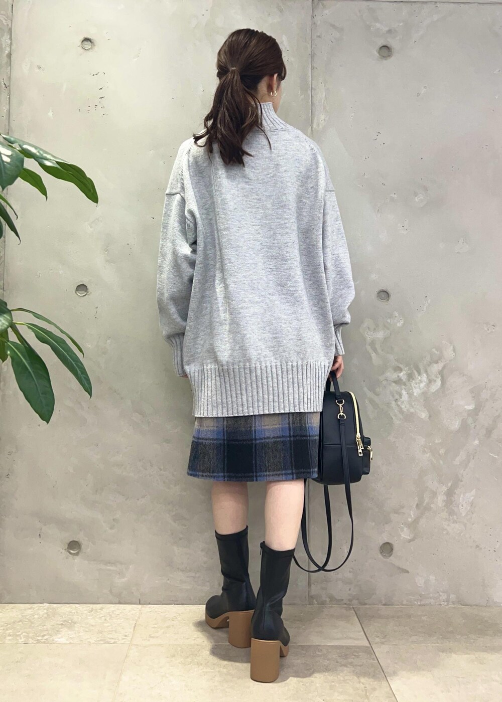 ブラック系のバックパック/リュック、グレー系のニット/セーター、ブラック系のブーツを着用したレディースの秋コーディネートの3枚目の写真