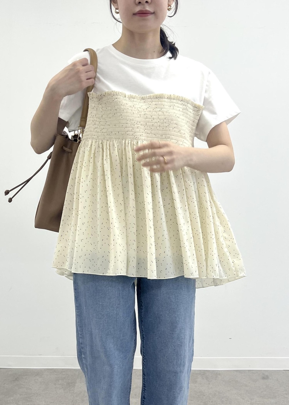 ブルー系のデニムパンツ、ブラウン系のショルダーバッグ、ブラック系のTシャツ/カットソーを着用したレディースの夏コーディネートの5枚目の写真