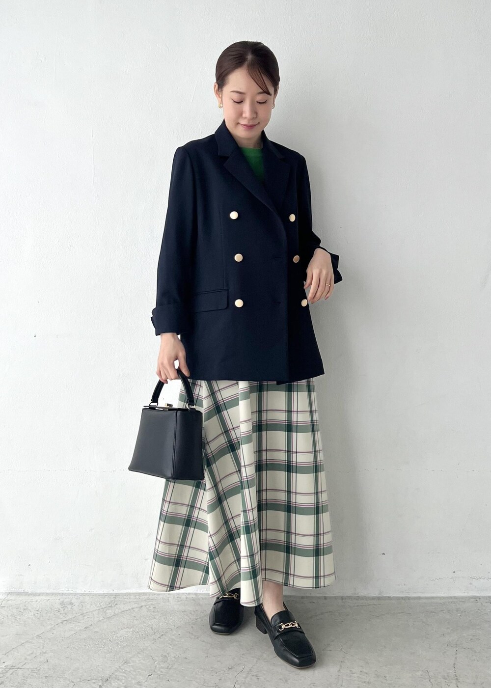 ブルー系のテーラードジャケット、グリーン系のスカート、グリーン系のニット/セーターを着用したレディースの春コーディネートの5枚目の写真