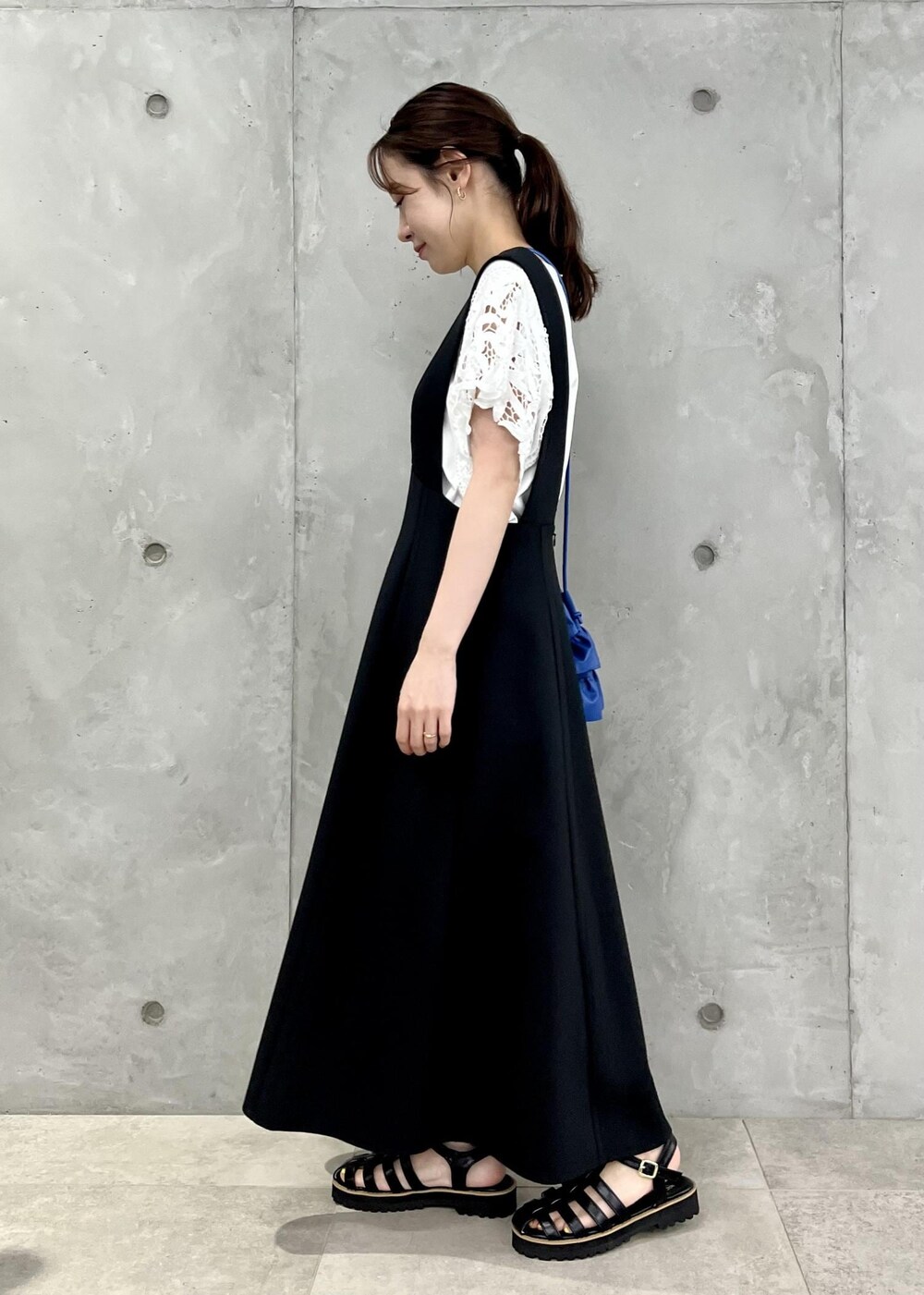 ブラック系のサンダル、ホワイト系のTシャツ/カットソー、ブルー系のショルダーバッグを着用したレディースの夏コーディネートの2枚目の写真