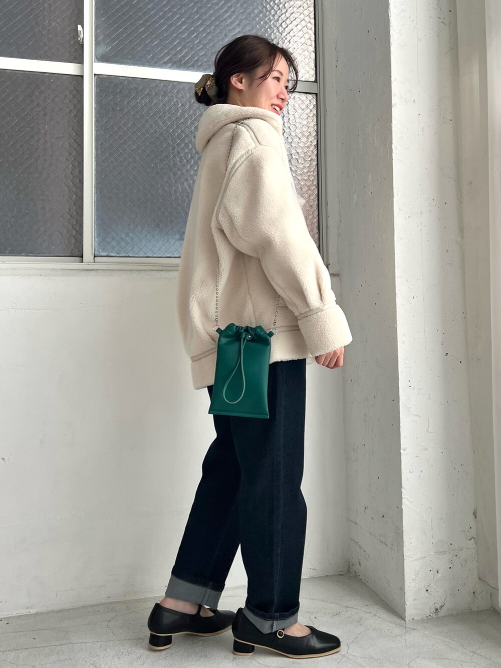 ホワイト系のカーディガン/ボレロ、ホワイト系のムートンコート、ブルー系のデニムパンツを着用したレディースの冬コーディネートの2枚目の写真