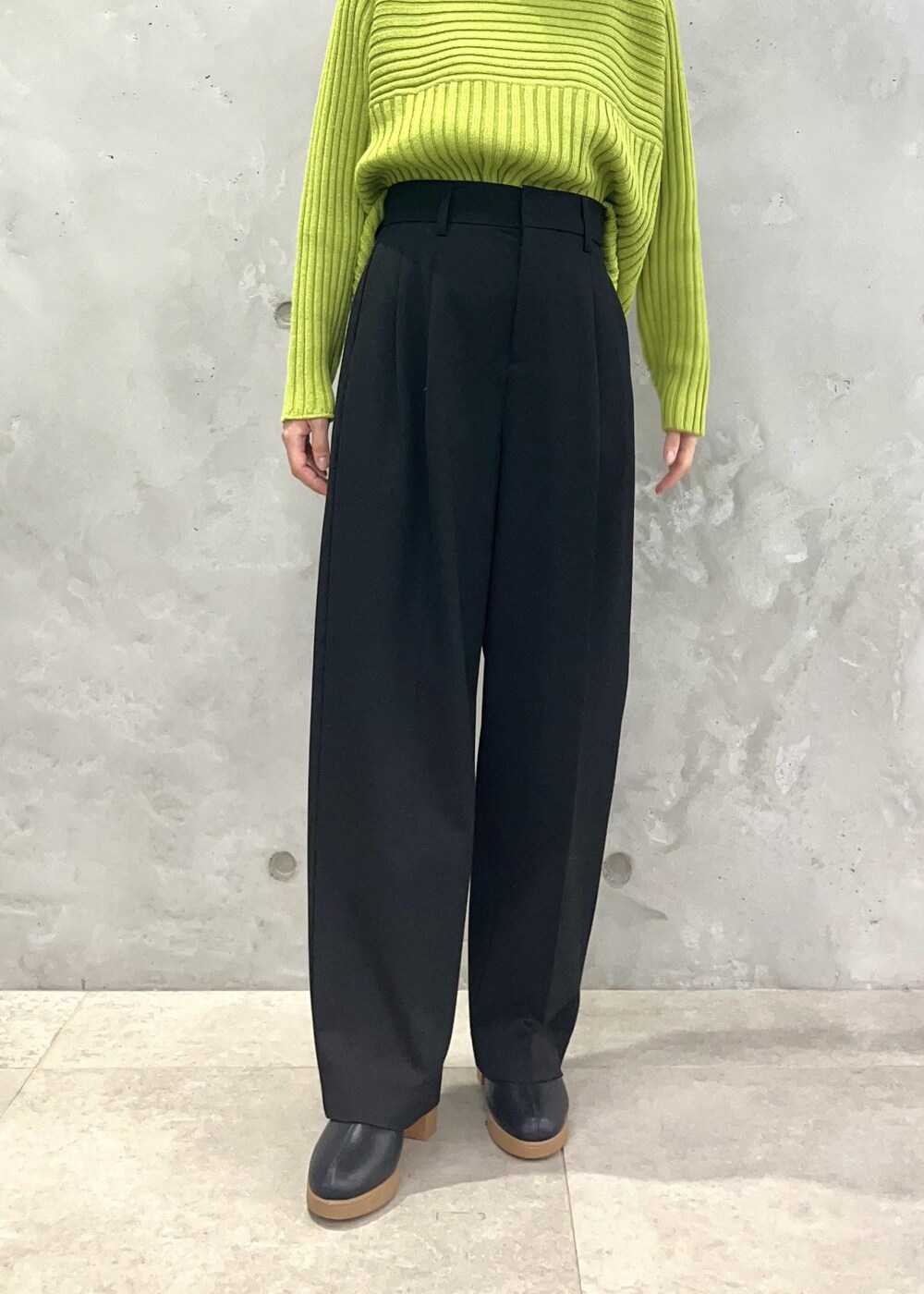 グリーン系のニット/セーター、ブラック系のショルダーバッグ、ブラック系のその他パンツを着用したレディースの秋コーディネートの5枚目の写真