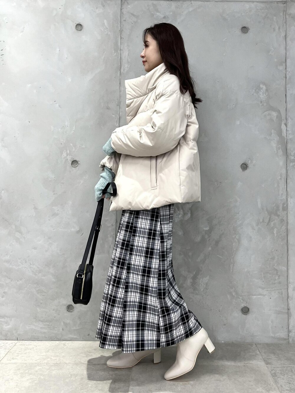 ホワイト系のダウンジャケット/コート、ホワイト系のスカート、ブラック系のショルダーバッグを着用したレディースの冬コーディネートの3枚目の写真