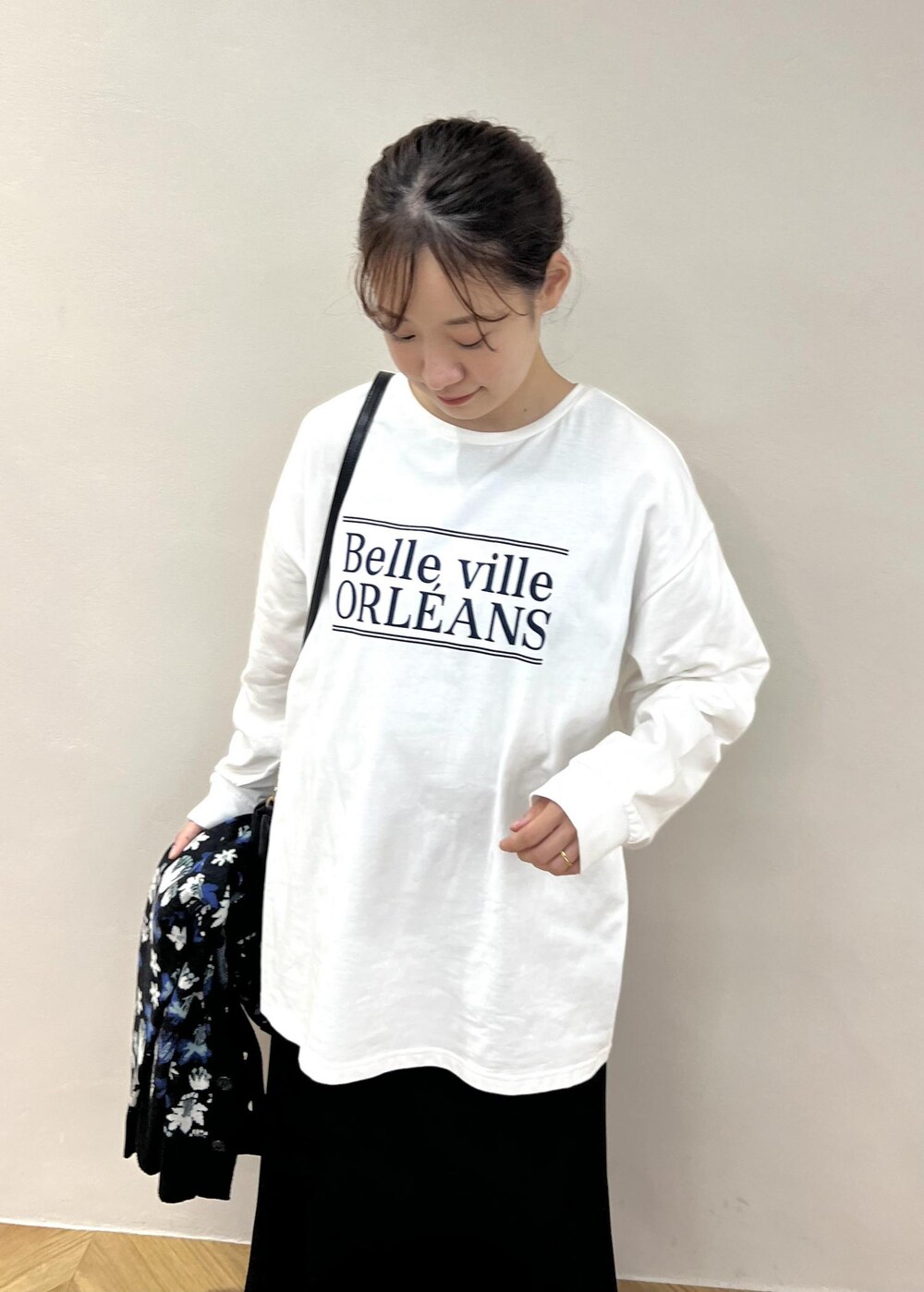 ブラック系のスカート、ホワイト系のTシャツ/カットソー、ブラック系のショルダーバッグを着用したレディースの秋コーディネートの4枚目の写真