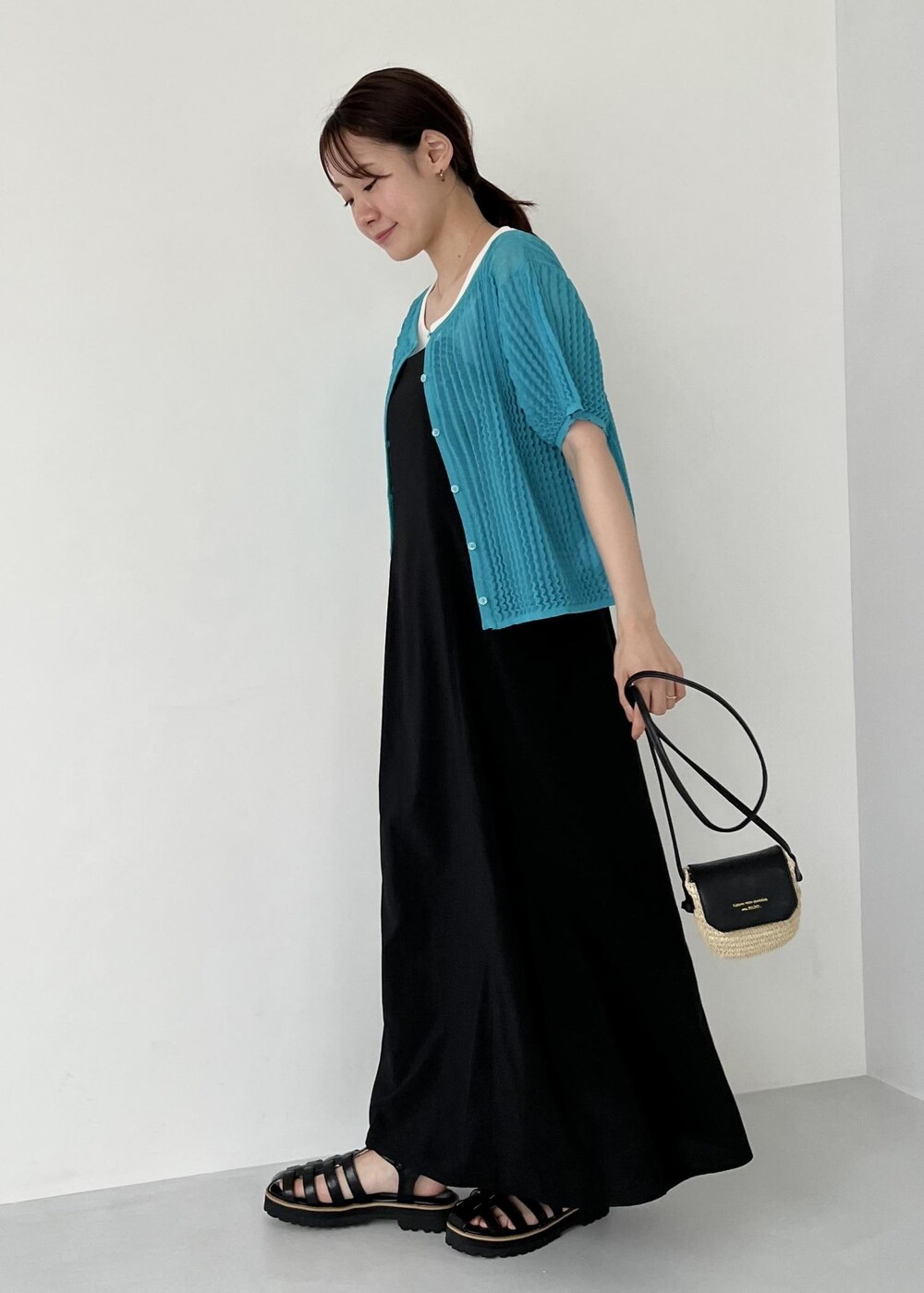 ブラック系のワンピース、ホワイト系のタンクトップ、ブラック系のサンダルを着用したレディースの夏コーディネートの2枚目の写真