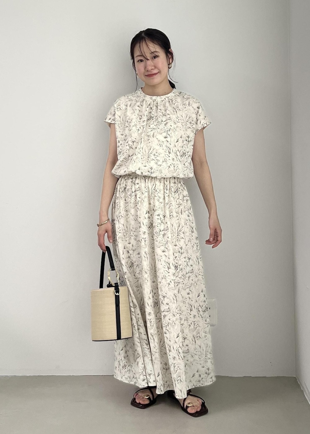 ホワイト系のブルゾン、ブラック系のサンダル、ホワイト系のワンピースを着用したレディースの春コーディネートの6枚目の写真