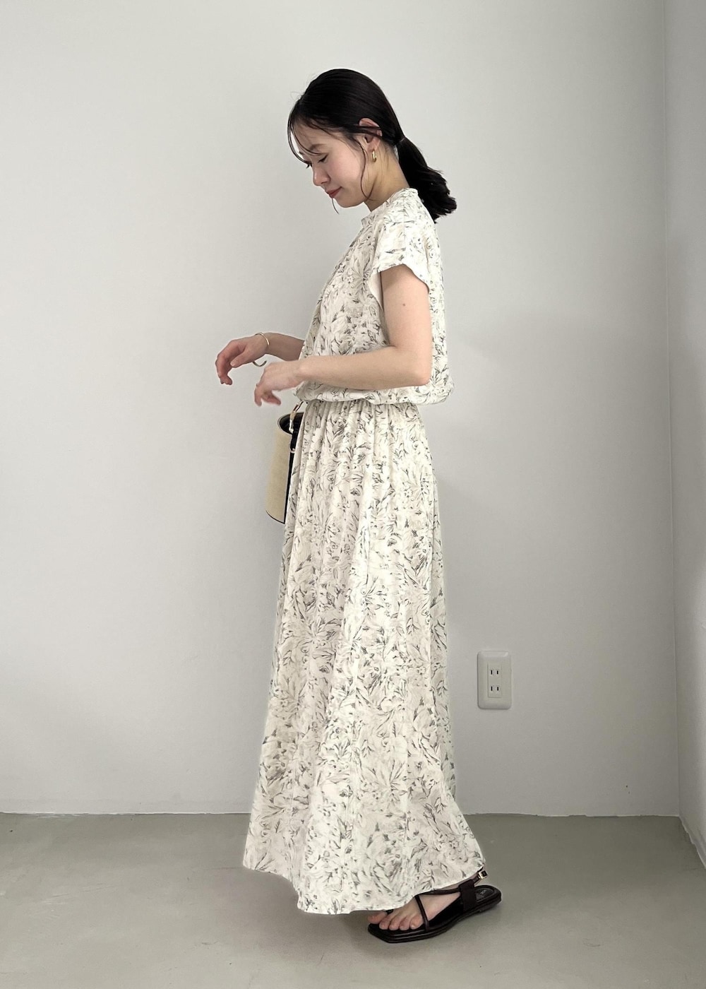 ホワイト系のブルゾン、ブラック系のサンダル、ホワイト系のワンピースを着用したレディースの春コーディネートの7枚目の写真