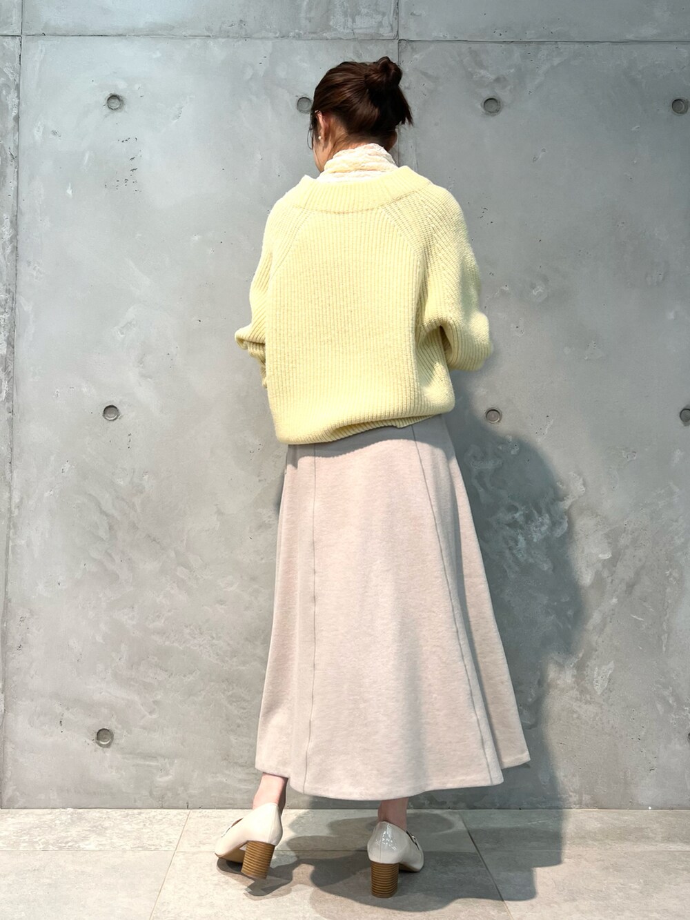 イエロー系のニット/セーター、ピンク系のスカート、イエロー系のボストンバッグを着用したレディースの冬コーディネートの4枚目の写真