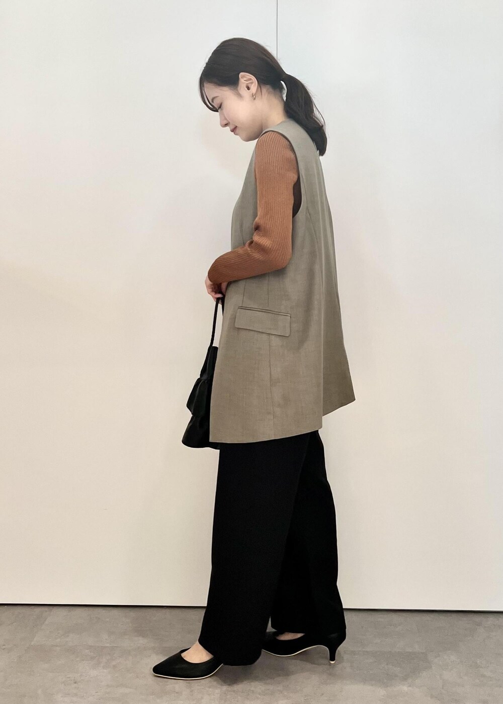ブラック系のトートバッグ、ブラック系のその他パンツ、ブラウン系のカーディガン/ボレロを着用したレディースの秋コーディネートの2枚目の写真