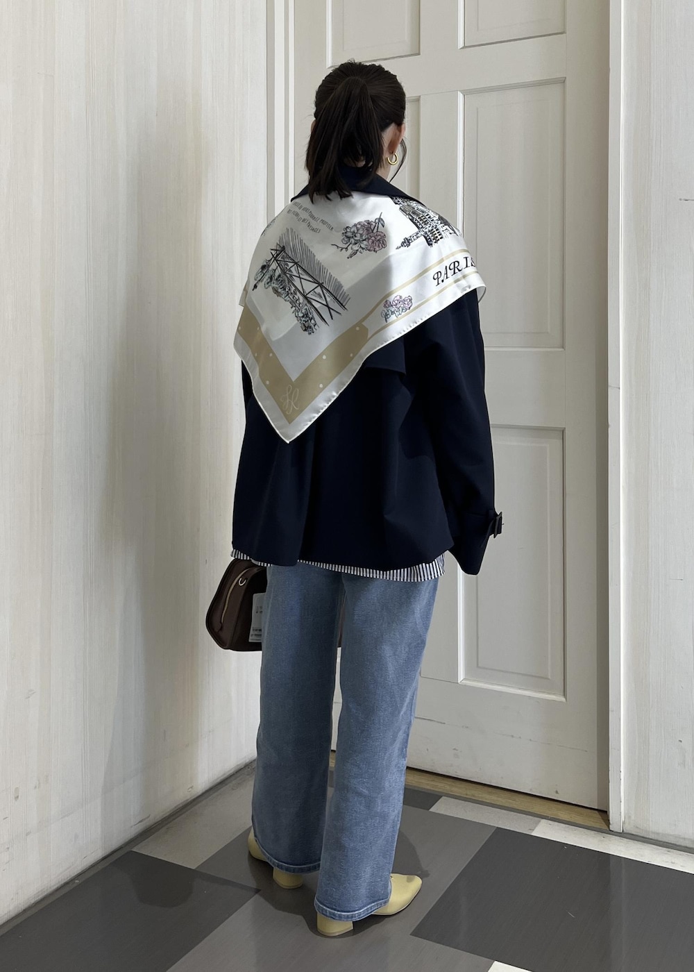 ブラウン系のボストンバッグ、ブルー系のトレンチコート、ブルー系のシャツ/ブラウスを着用したレディースの春コーディネートの4枚目の写真