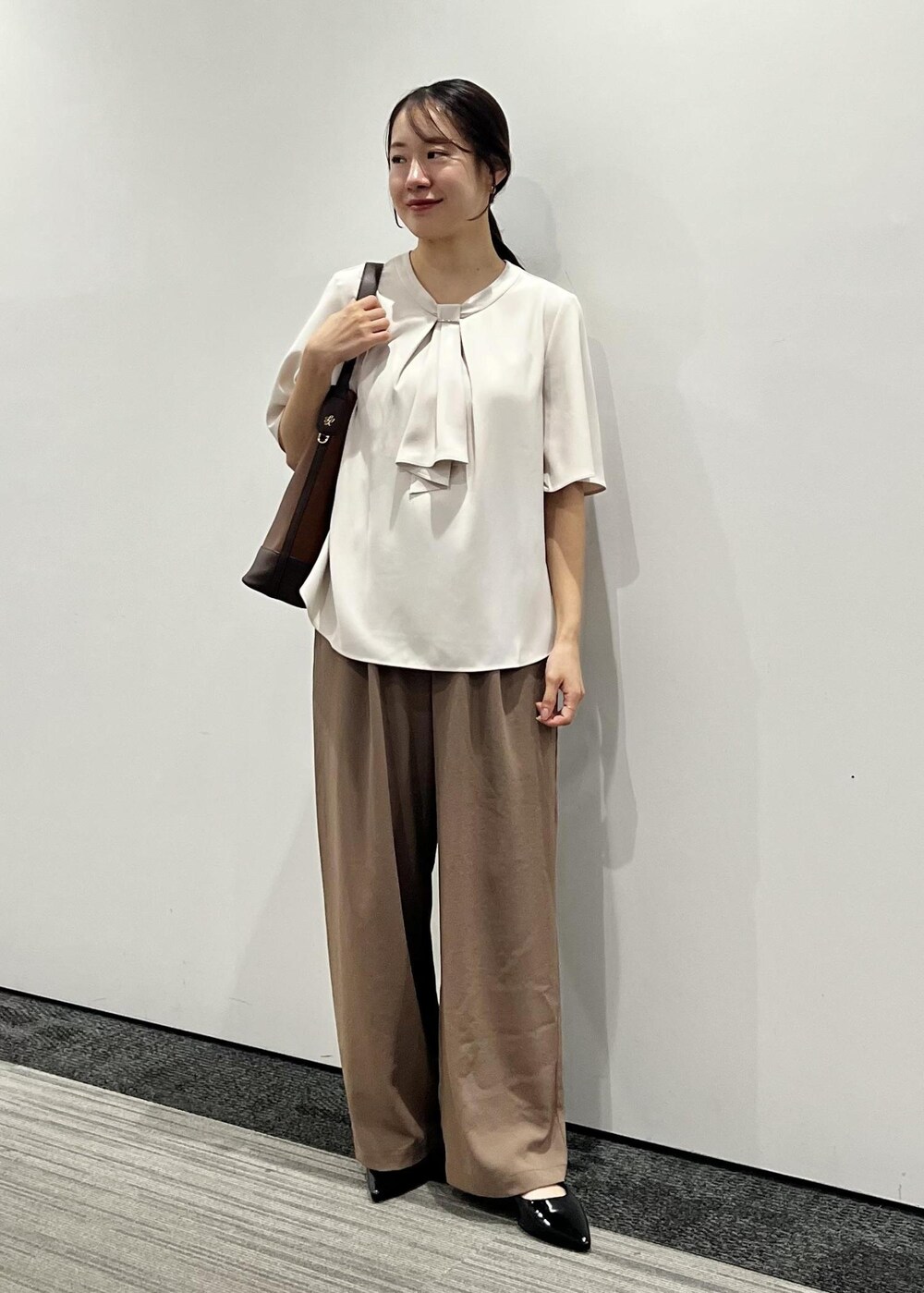 ブラウン系のその他パンツ、ベージュ系のシャツ/ブラウス、ブラック系のパンプスを着用したレディースの夏コーディネートの2枚目の写真