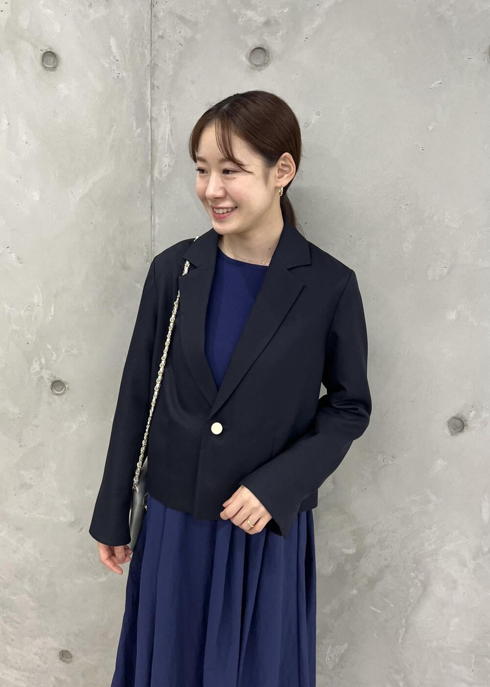 シルバー系のショルダーバッグ、ブラック系のサンダル、ブルー系のテーラードジャケットを着用したレディースの夏コーディネートの6枚目の写真