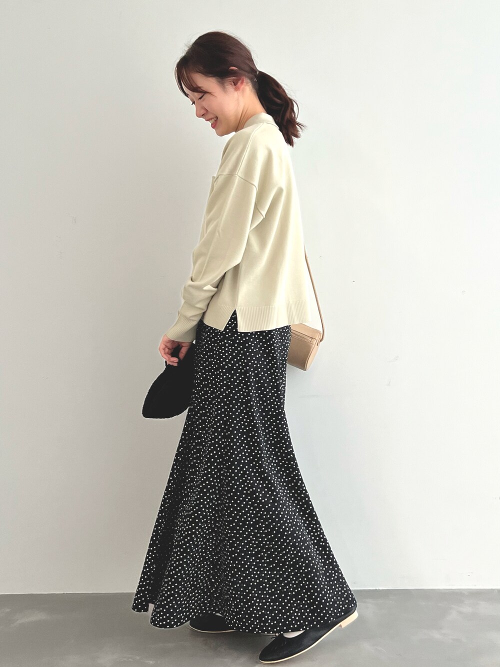ベージュ系のニット/セーター、ブラック系のスカート、ブラック系のバレエシューズを着用したレディースの春コーディネートの3枚目の写真