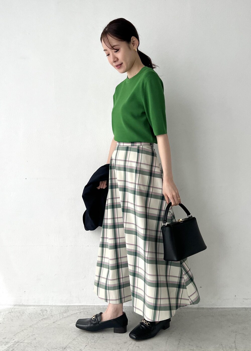 ブルー系のテーラードジャケット、グリーン系のスカート、グリーン系のニット/セーターを着用したレディースの春コーディネートの2枚目の写真