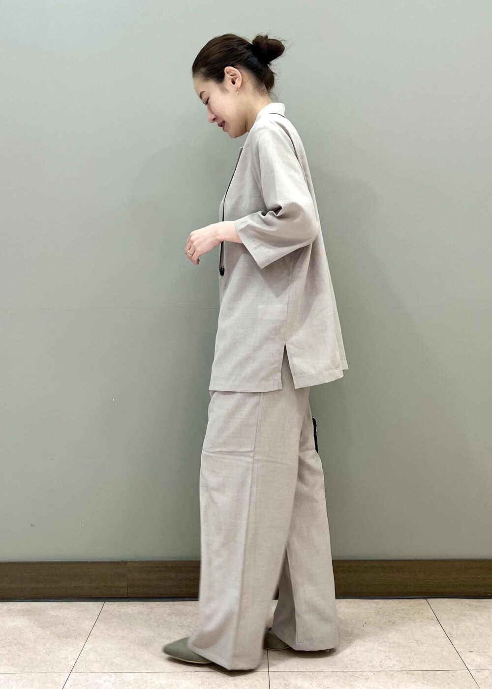 ブラック系のボストンバッグ、ベージュ系のテーラードジャケット、ホワイト系のTシャツ/カットソーを着用したレディースの夏コーディネートの6枚目の写真