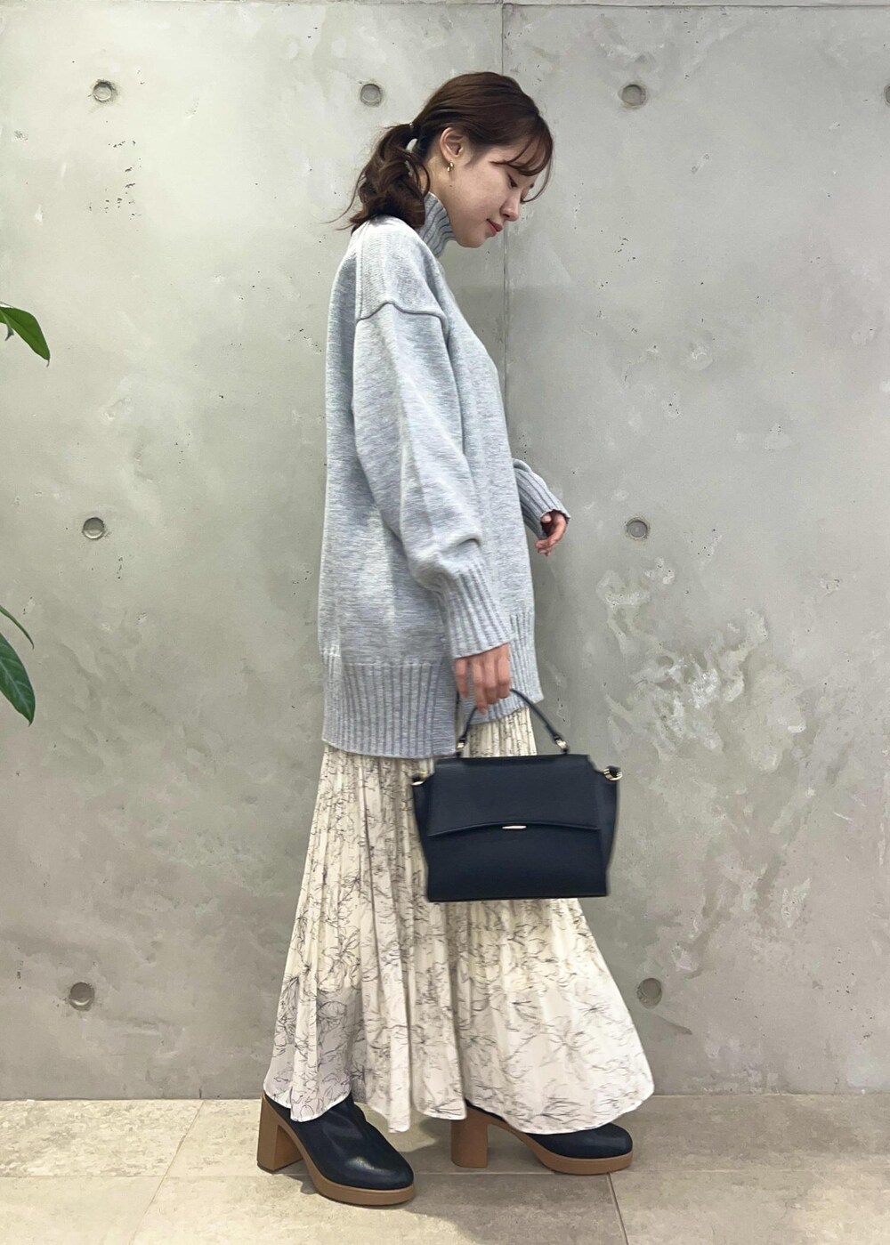 ホワイト系のスカート、グレー系のニット/セーター、ブラック系のショルダーバッグを着用したレディースの冬コーディネートの5枚目の写真