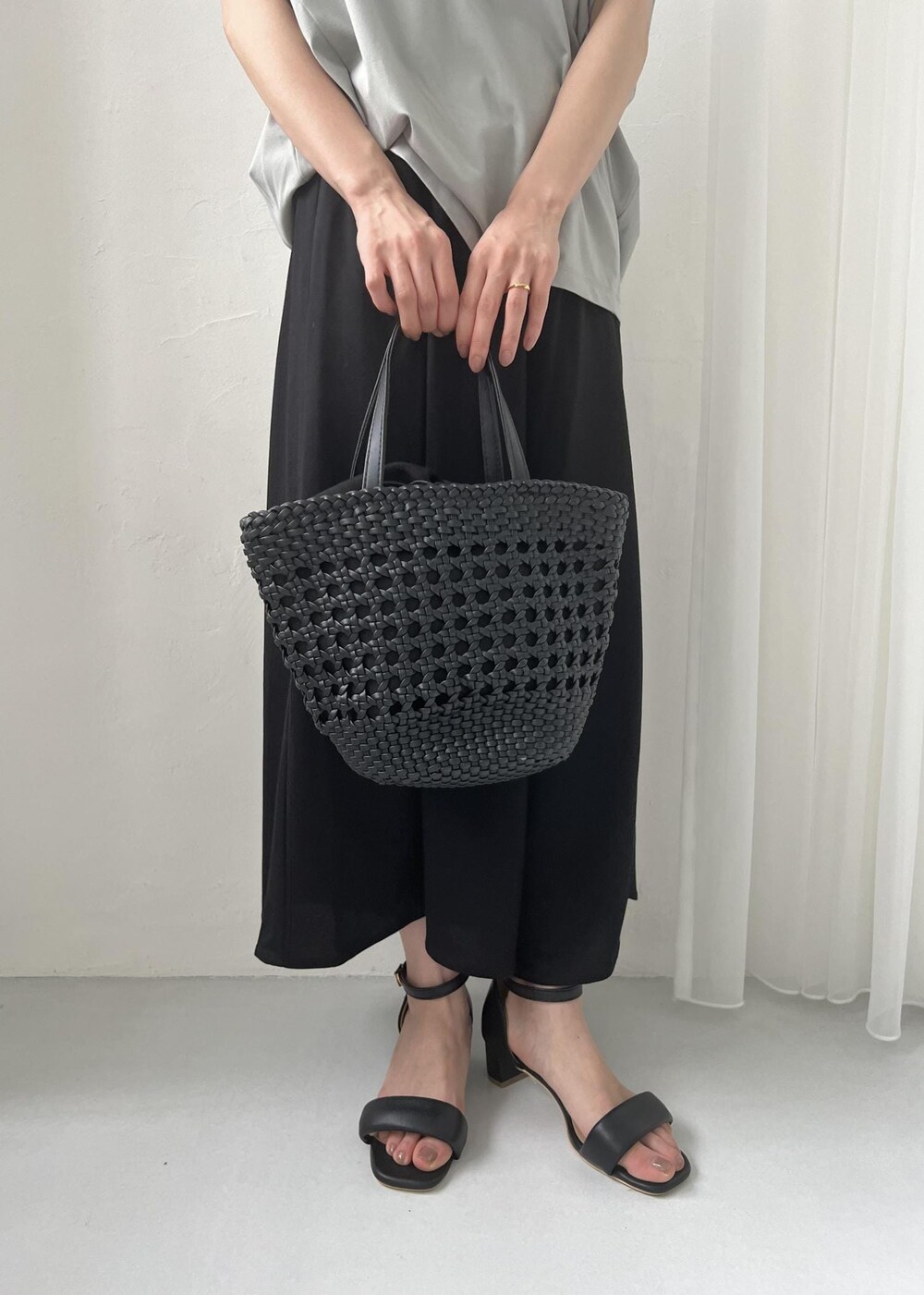 ブラック系のサンダル、ブラック系のトートバッグ、グリーン系のTシャツ/カットソーを着用したレディースの春コーディネートの7枚目の写真