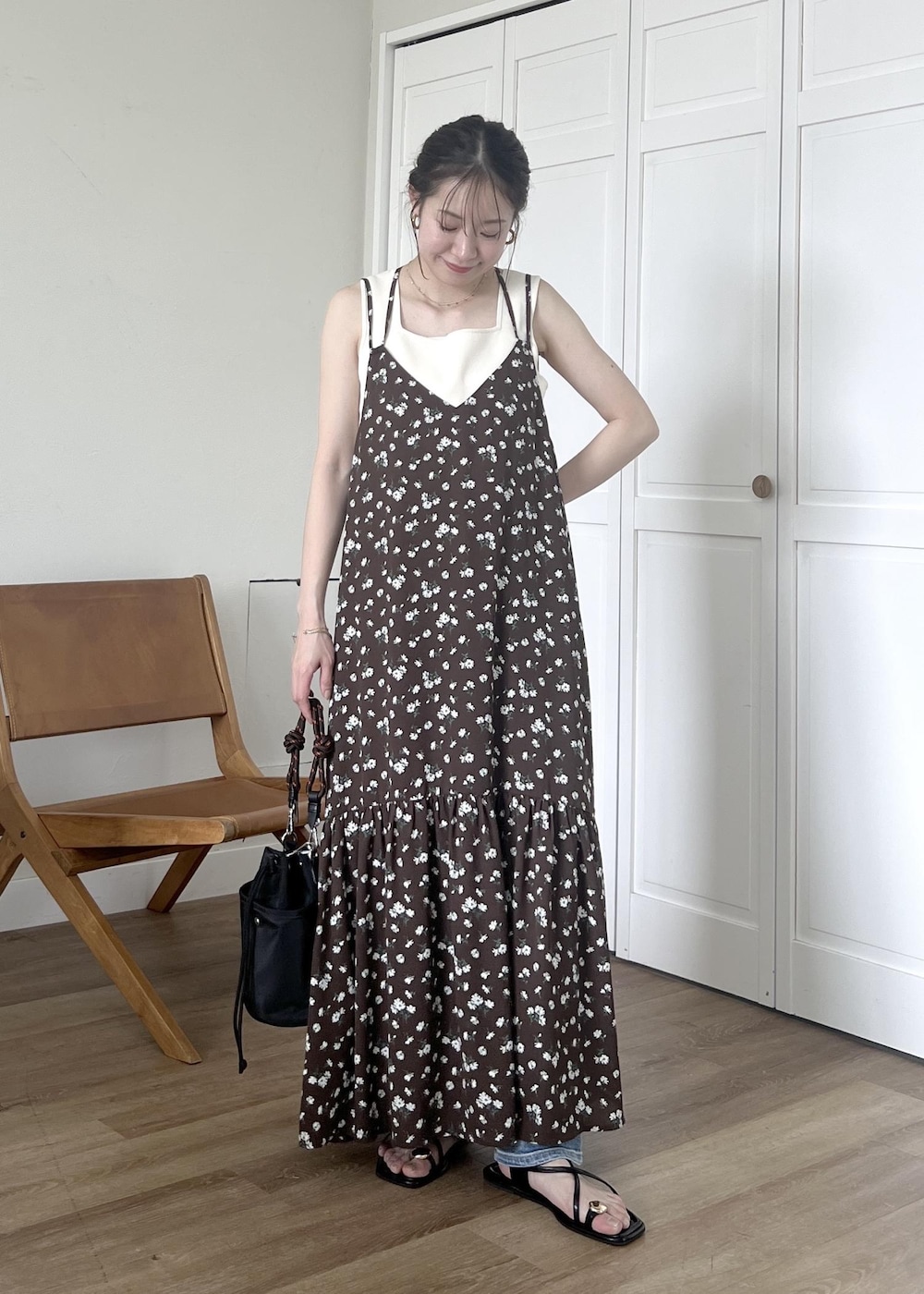 ブルー系のデニムパンツ、ブラック系のショルダーバッグ、ホワイト系のタンクトップを着用したレディースの春コーディネートの5枚目の写真