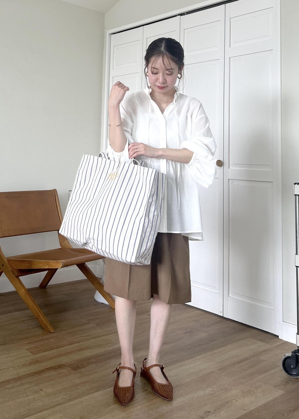ブルー系のトートバッグ、ホワイト系のシャツ/ブラウス、イエロー系のその他パンツを着用したレディースの春コーディネートの2枚目の写真