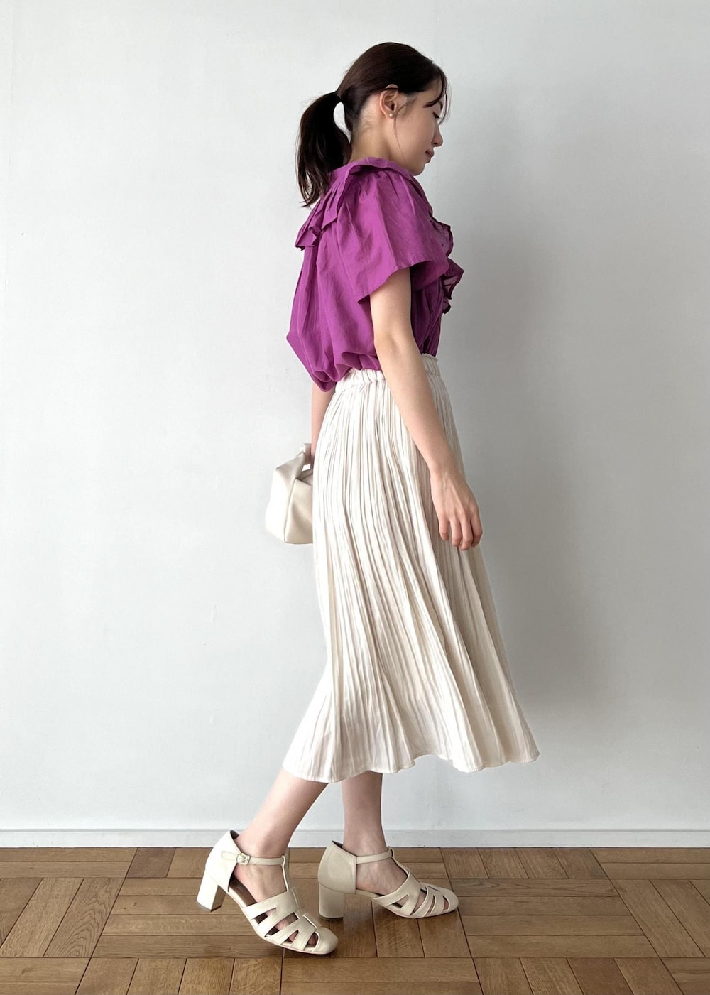 ベージュ系のスカート、ホワイト系のサンダル、ホワイト系のショルダーバッグを着用したレディースの夏コーディネートの2枚目の写真