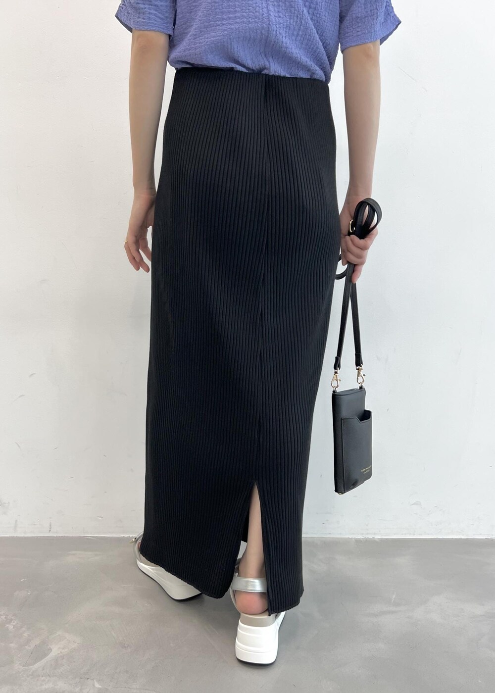 ブラック系のショルダーバッグ、ブルー系のTシャツ/カットソー、ブラック系のスカートを着用したレディースの夏コーディネートの5枚目の写真