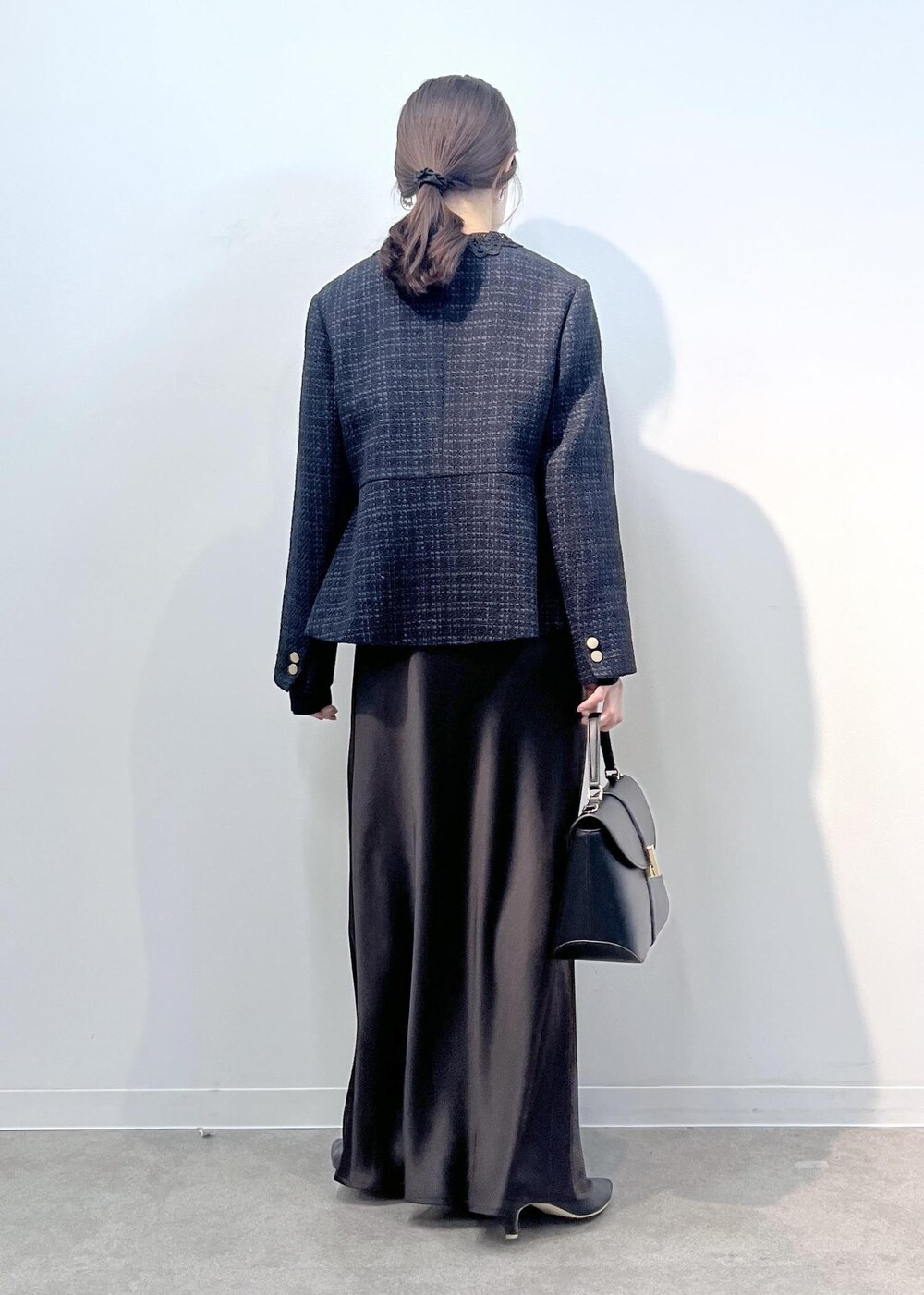 ブルー系のノーカラージャケット、ブラック系のショルダーバッグ、ブルー系のニット/セーターを着用したレディースの冬コーディネートの4枚目の写真