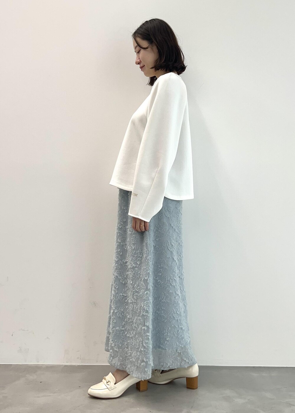 ホワイト系のローファー、ホワイト系のTシャツ/カットソー、ブルー系のスカートを着用したレディースの春コーディネートの4枚目の写真