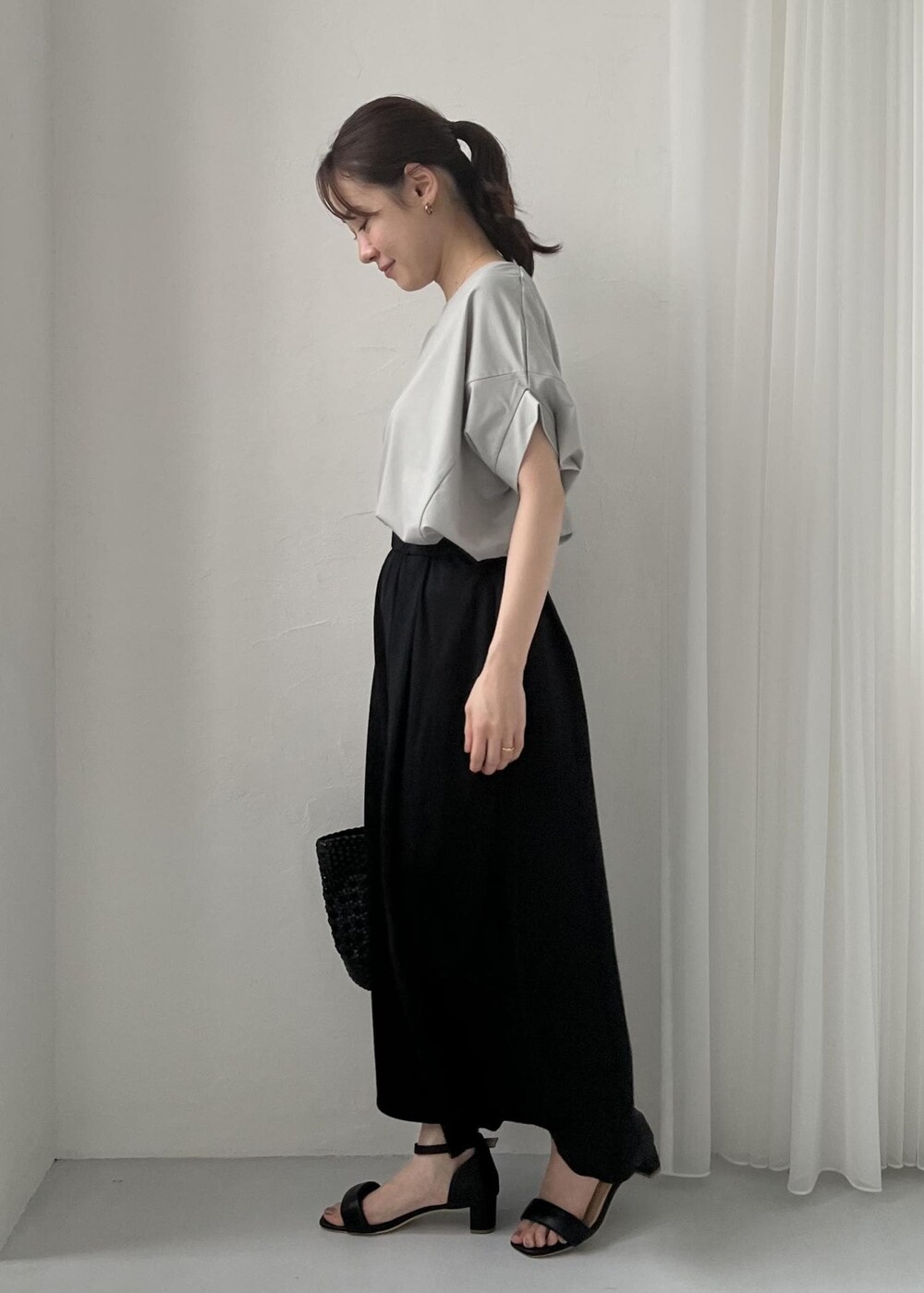 ブラック系のサンダル、ブラック系のトートバッグ、グリーン系のTシャツ/カットソーを着用したレディースの春コーディネートの2枚目の写真
