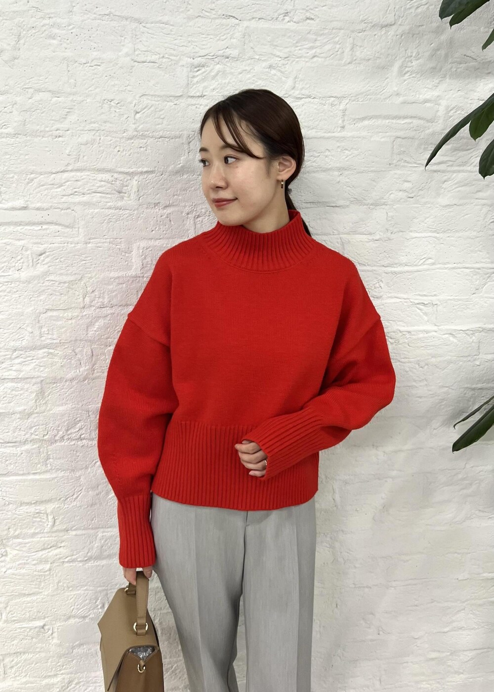 レッド系のニット/セーター、グレー系のその他パンツ、ブラック系のパンプスを着用したレディースの秋コーディネートの4枚目の写真