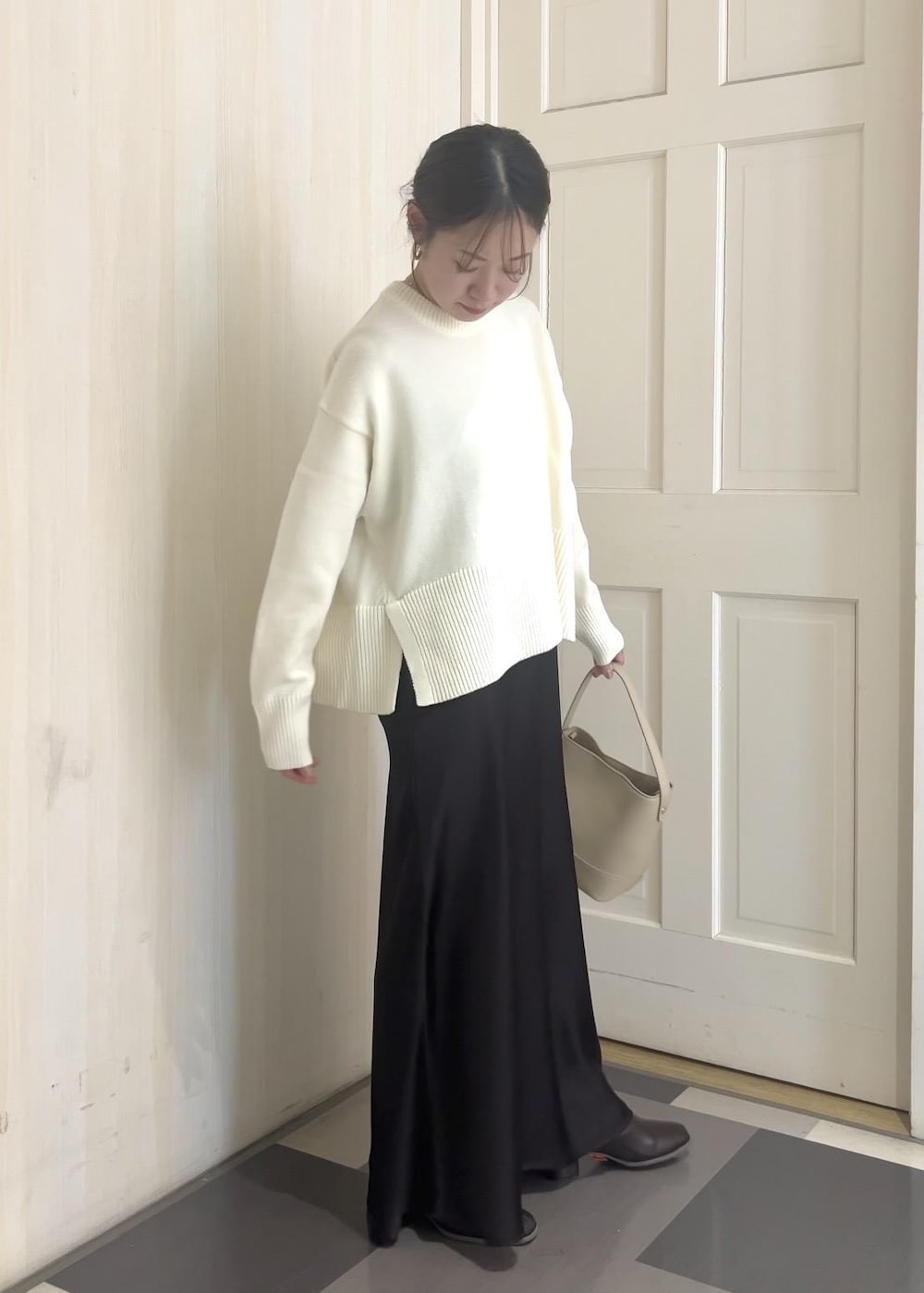 ホワイト系のニット/セーター、ブラウン系のその他アウター、ベージュ系のショルダーバッグを着用したレディースの冬コーディネートの2枚目の写真