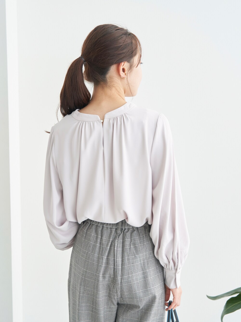 パープル系のシャツ/ブラウス、ブラック系のパンプス、ブラック系のショルダーバッグを着用したレディースの秋コーディネートの5枚目の写真