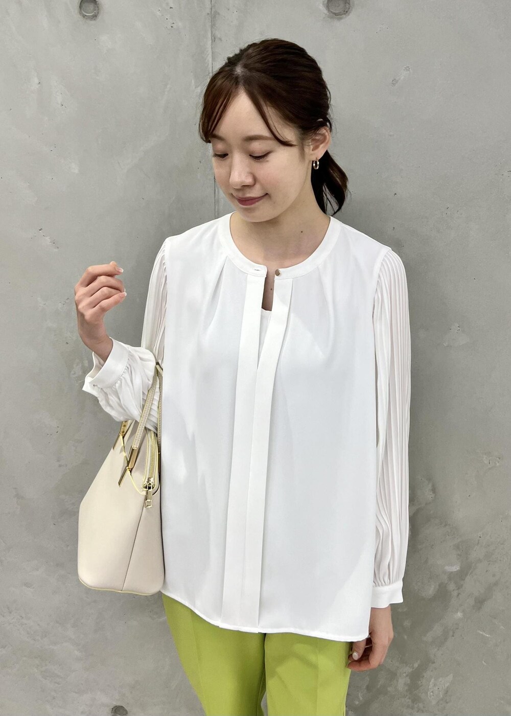 ホワイト系のシャツ/ブラウス、ホワイト系のショルダーバッグ、グリーン系のスラックスを着用したレディースの春コーディネートの4枚目の写真