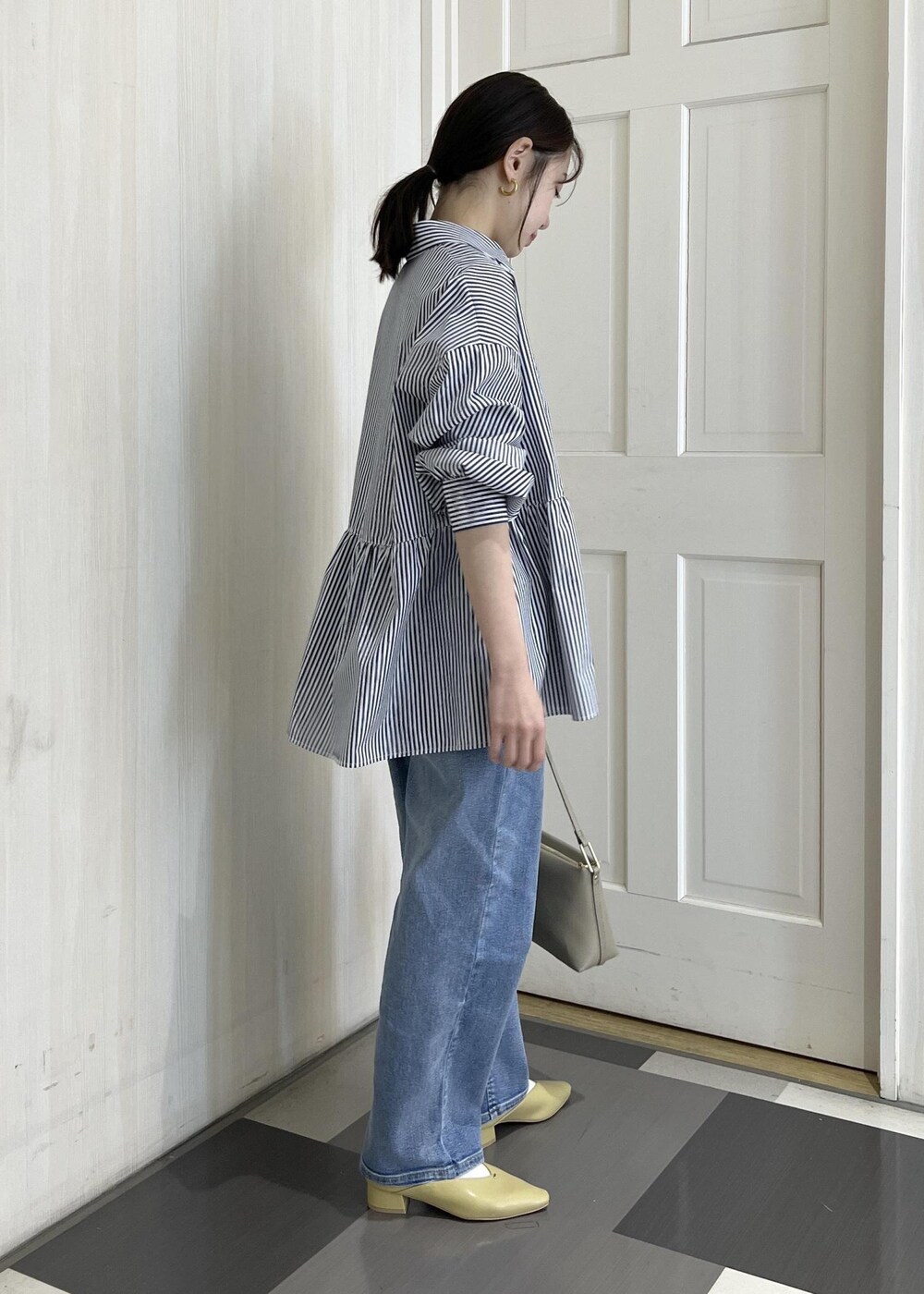 ブラウン系のボストンバッグ、ブルー系のトレンチコート、ブルー系のシャツ/ブラウスを着用したレディースの春コーディネートの7枚目の写真