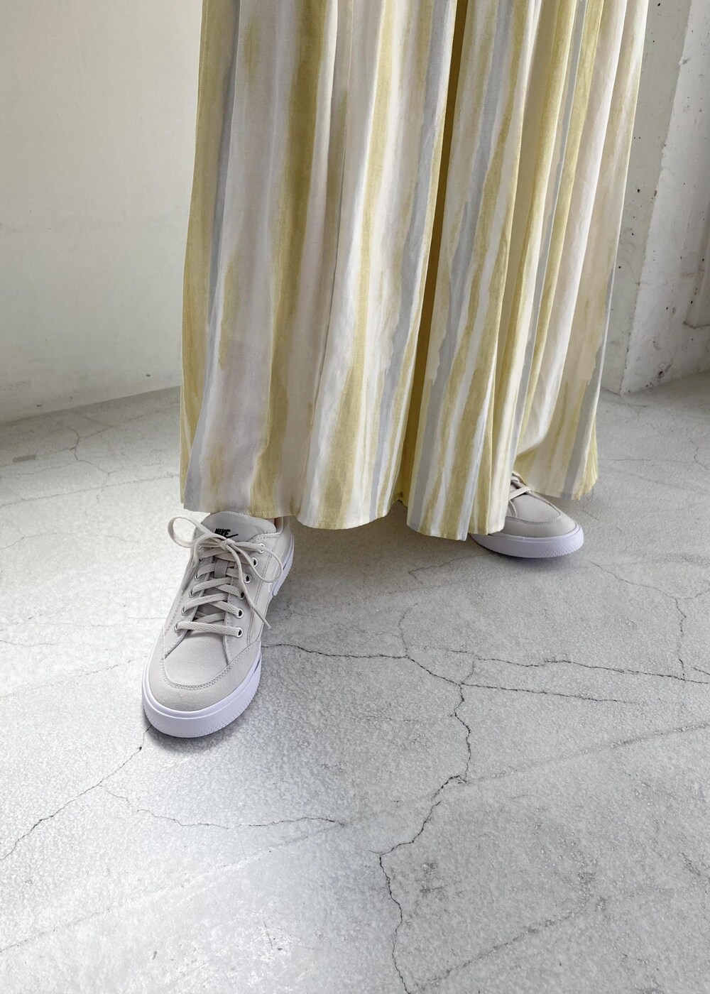 イエロー系のスカート、ホワイト系のニット/セーターを着用したレディースの夏コーディネートの4枚目の写真