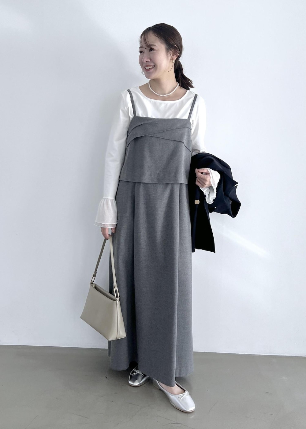 ホワイト系のTシャツ/カットソー、グレー系のワンピース、ベージュ系のショルダーバッグを着用したレディースの冬コーディネートの5枚目の写真