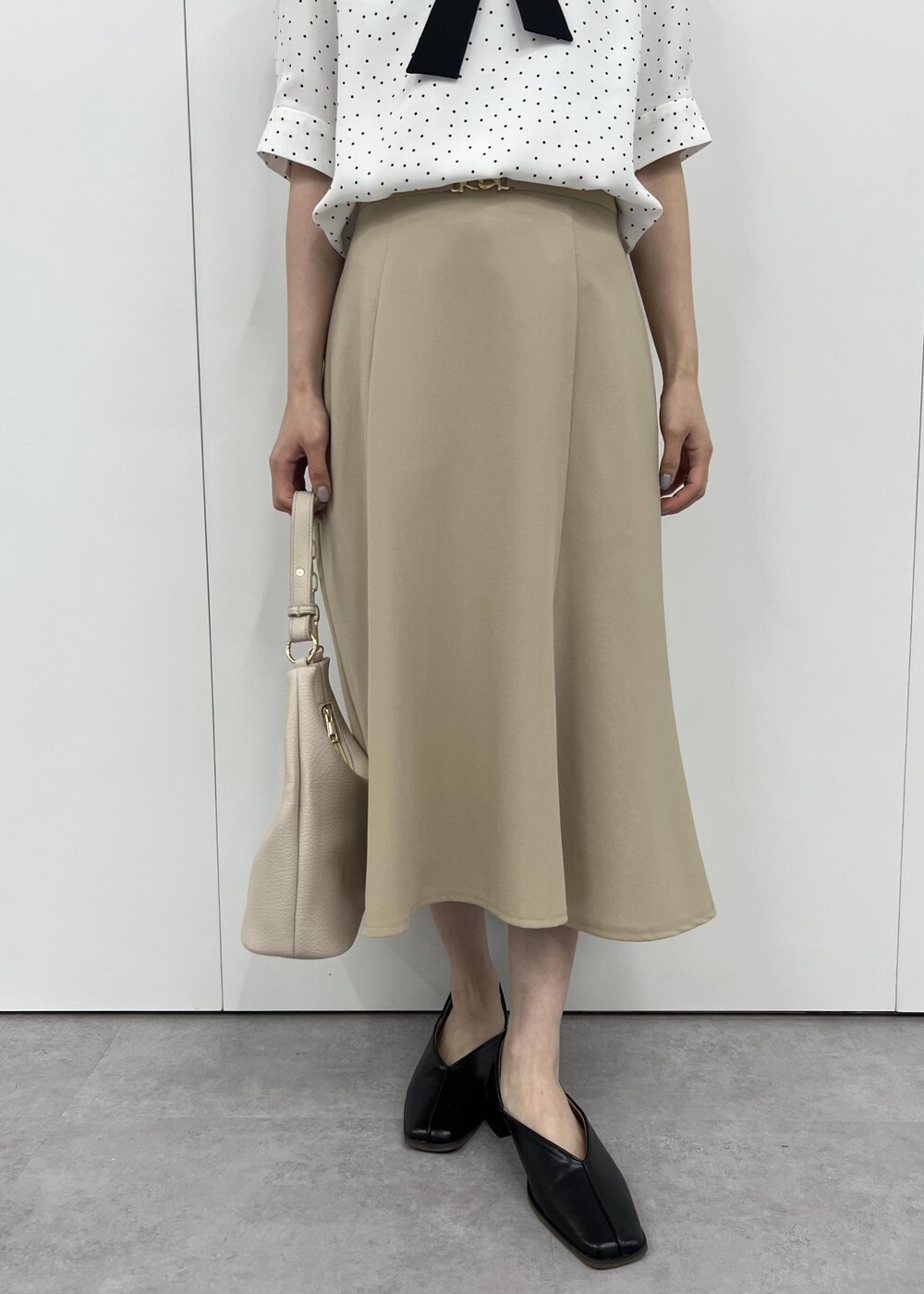 ベージュ系のショルダーバッグ、ベージュ系のスカート、ホワイト系のシャツ/ブラウスを着用したレディースの夏コーディネートの5枚目の写真