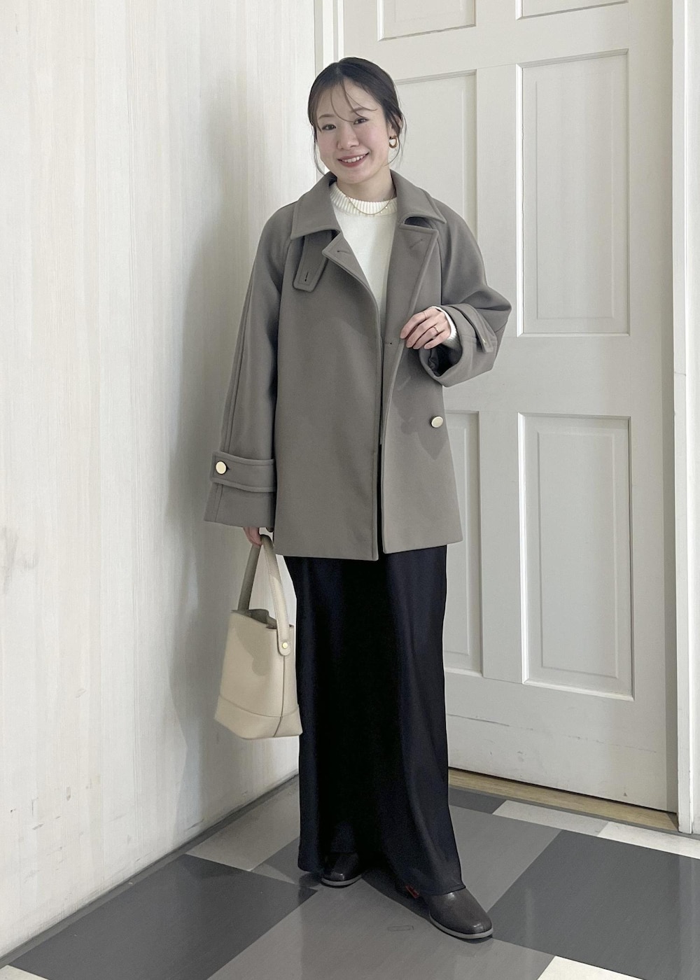 ホワイト系のニット/セーター、ブラウン系のその他アウター、ベージュ系のショルダーバッグを着用したレディースの冬コーディネートの4枚目の写真